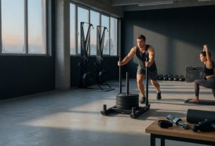 HYROX-Trainingsszene: Athlet schiebt einen Schlitten; Wearables, Recovery-Tools und Mobility-Szene sichtbar, sauberes Ed