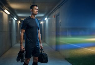 Cristiano Ronaldo in a neutral kit stands in a stadium tunnel at dusk, rim-lit