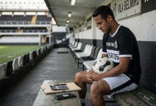 Neymar sits alone on a bench in Santos FC’s stadium tunnel in a plain